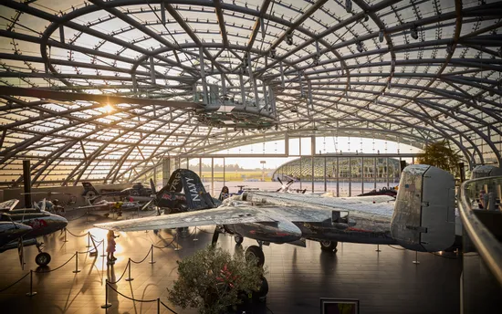 Innenansicht des Hangar-7 bei Sonnenuntergang mit Glasarchitektur und Ausstellungsexponaten